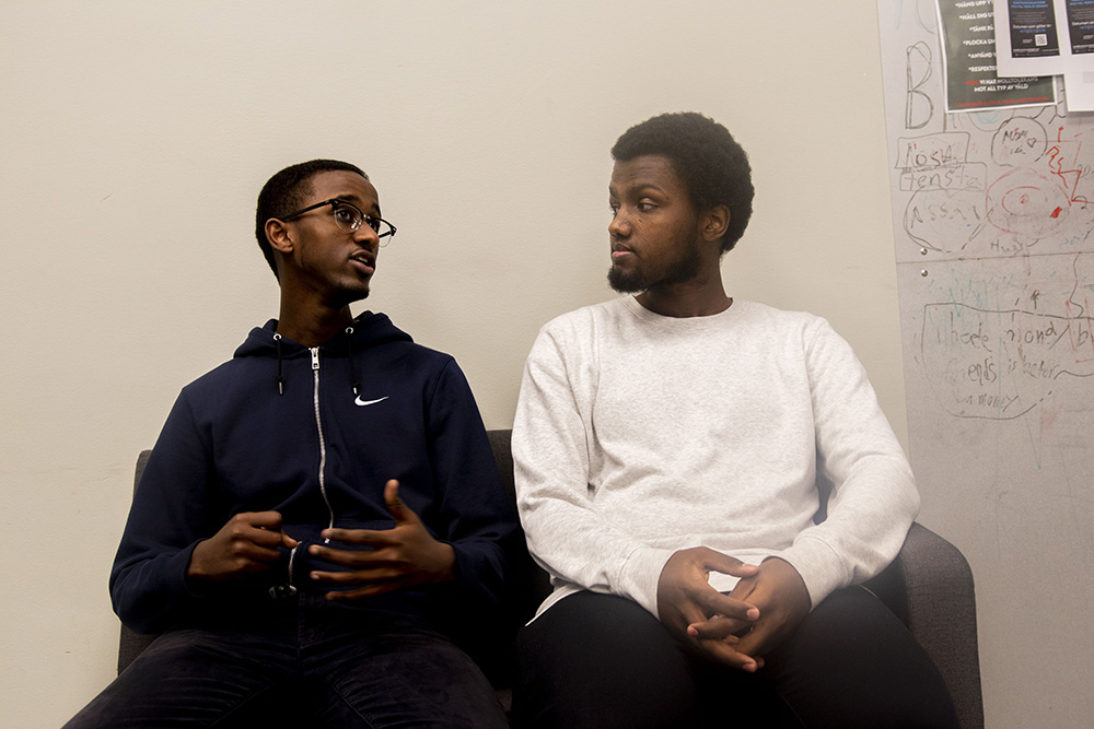 Två ungdomar sitter i en soffa och pratar.