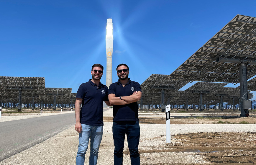 Två personer står framför en solenergianläggning.
