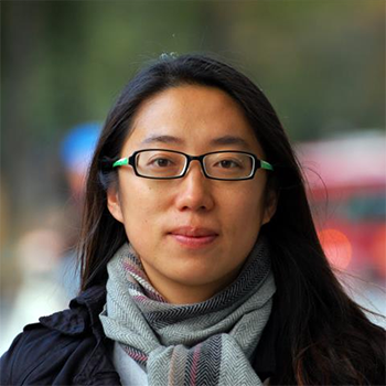 Portrait photo: A young woman with dark hair and glasses.