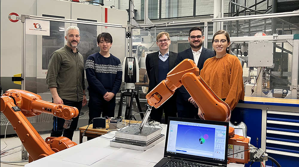 The researchers posing with the robot