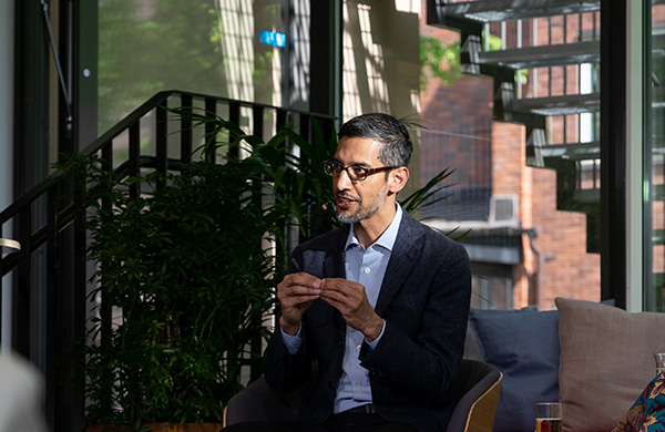 Sundar Pichai sitting in a chair talking and gesticulating with his hands