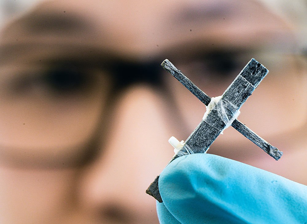 Forskare visar upp transistorn, två träbitar som bildar ett kors