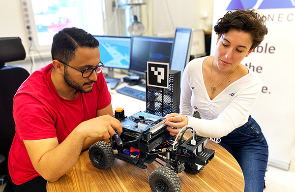 A man and a woman working on a radio-controlled car