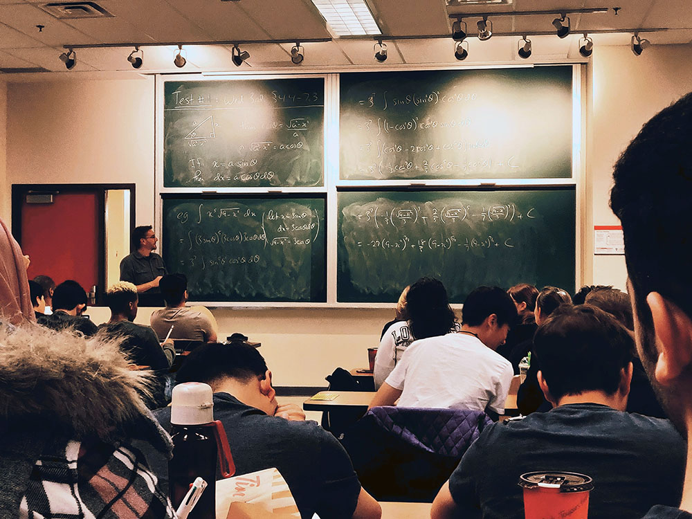 undervisning i klassrum framför en griffeltavla med olika matematiska formler