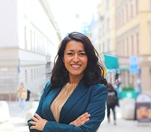 A woman with dark long hair and a blue jacket.