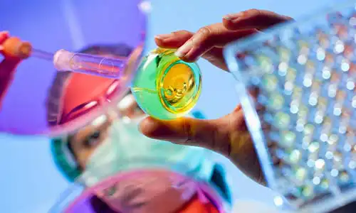 Forskare med provrör i labbmiljö.