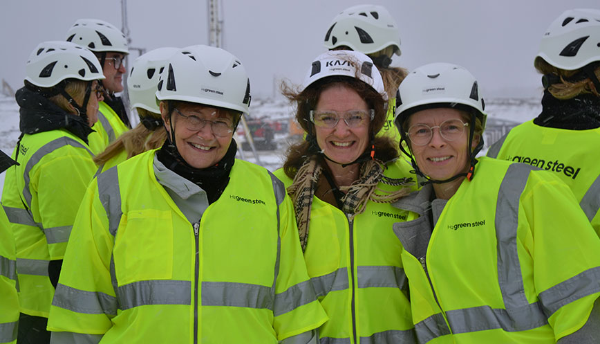 Three women with helmets and reflective vests.