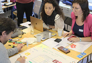 A group of people working on a large pirce of paper together