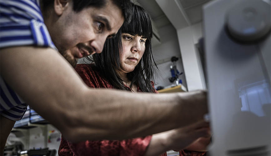 A man and a woman in front of computer screen