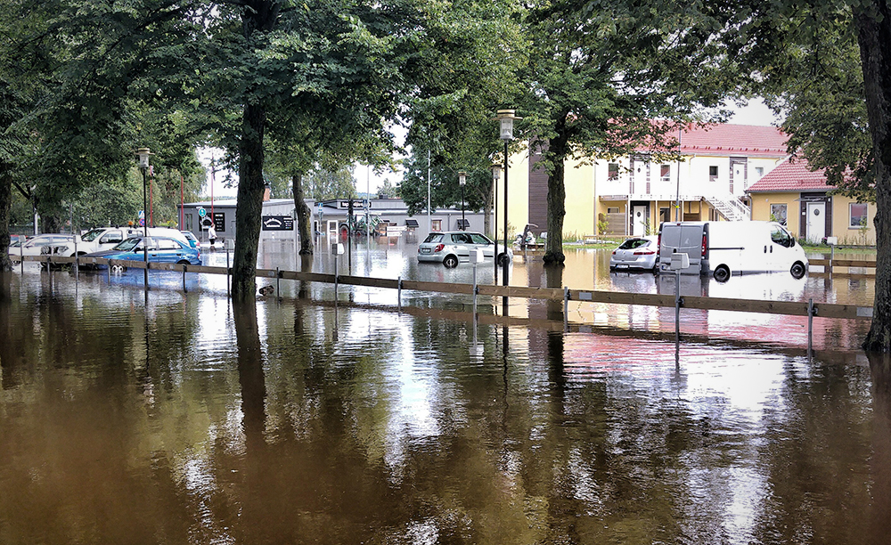 Flooded car park with parked cars.