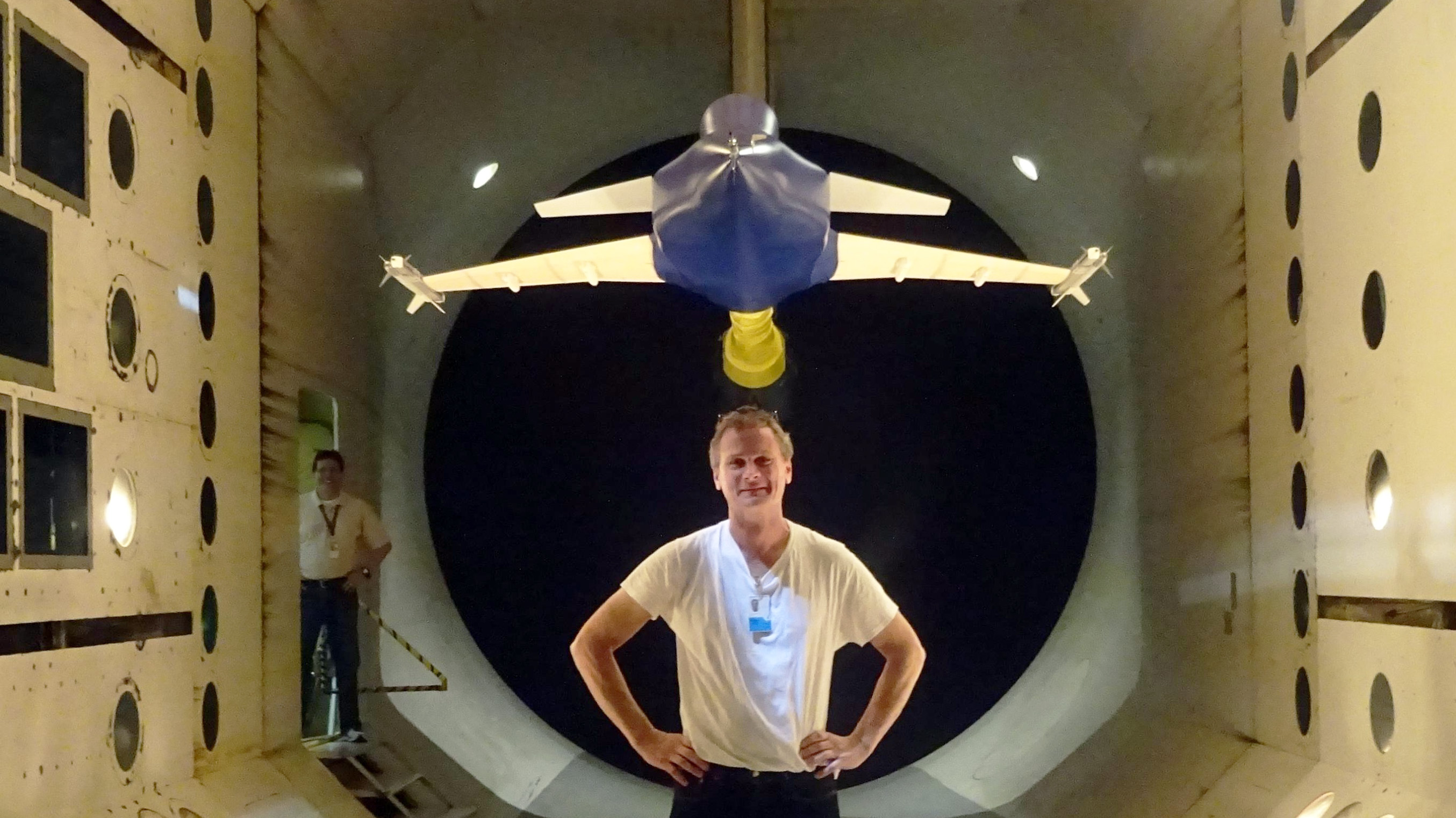 Professor Ulf Ringertz står framför ett modelflygplan i vindtunneln