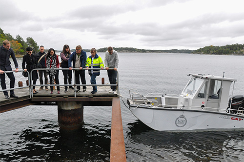 People standing on a pier next to an aluminium boat
