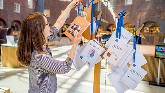 Doctoral student hanging up her dissertation