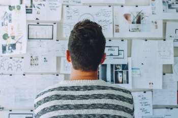 En man som står framför en whiteboard med massa uträkningar och data