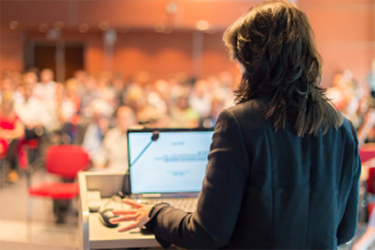 Person standing in front of an audience holding a presentation