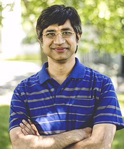 portrait Saikat Chatterjee in blue shirt outdoors in green environment