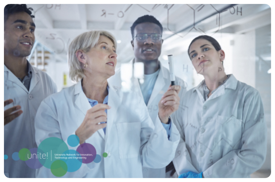 Two men and two women in lab coats looking at something
