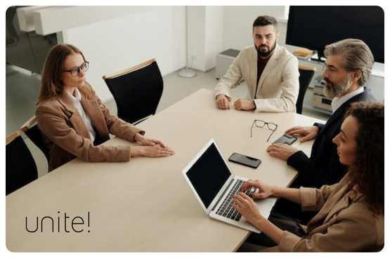 Two women and two men sitting around a meeting room table