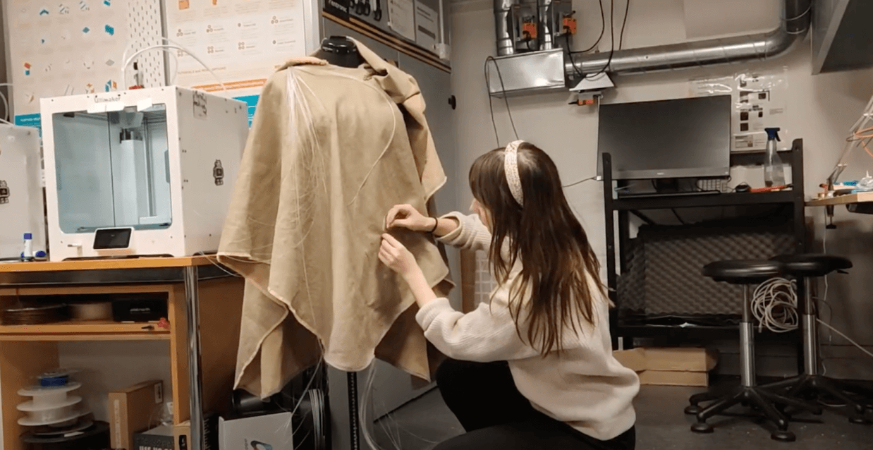 Student Maria Moliteus stitching optic fibers onto her interactive solar cloak (@Middla autumn 2023)