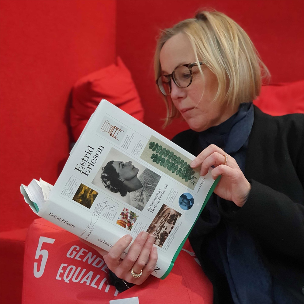 Librarian reading book, leaning on pillow with the text gender equality