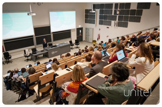 En grupp människor som lyssnar på en talare i en föreläsningssal