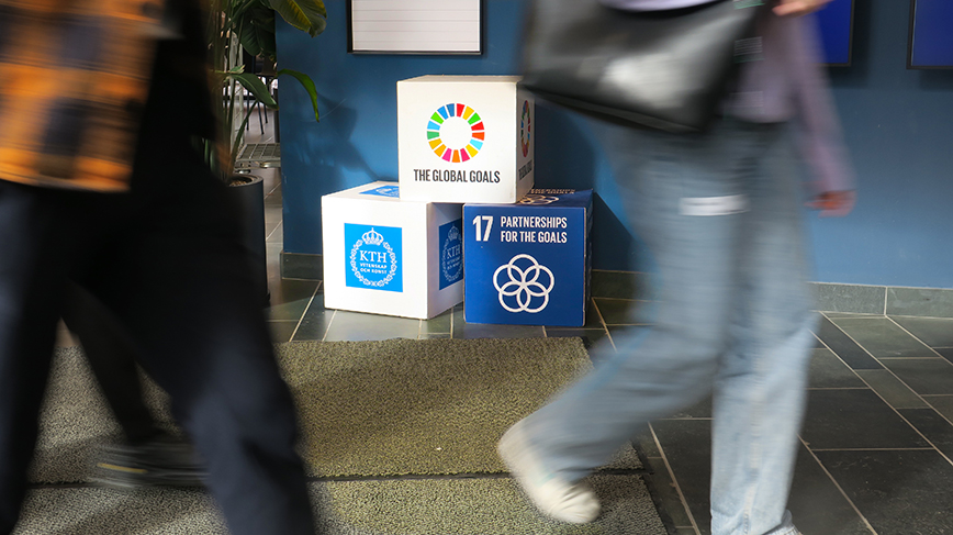 People walking past a display showing the KTH logo and SDGs artwork