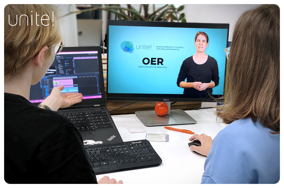 Two students looking at a computer screen with a woman teaching