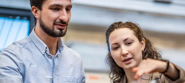 Två personer står i ett labb