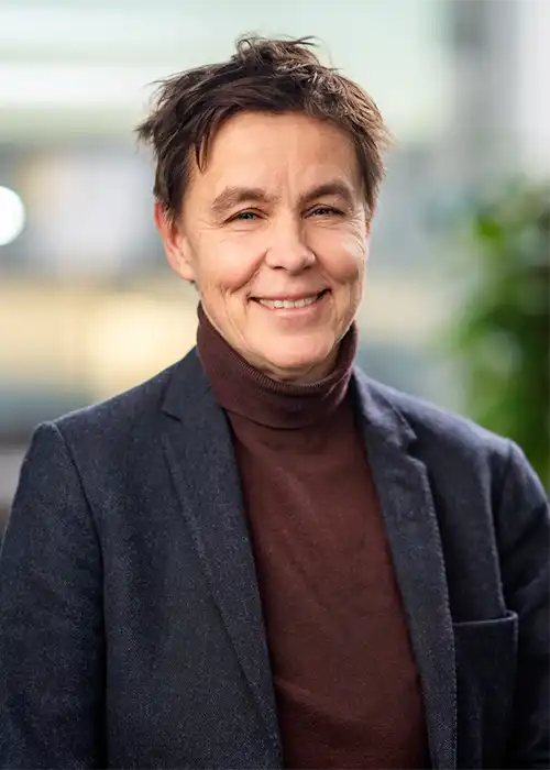 Porträttfoto av kvinna med kort hår och skjorta.