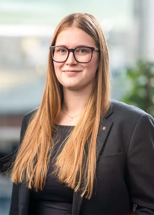 Porträttfoto av kvinna med glasögon och långt hår.