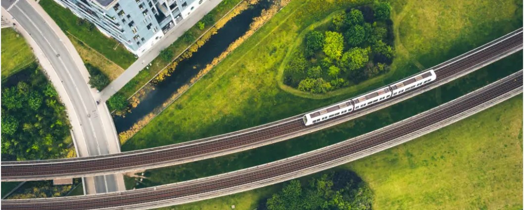 Aerial view of railway and road surrounded by green environment