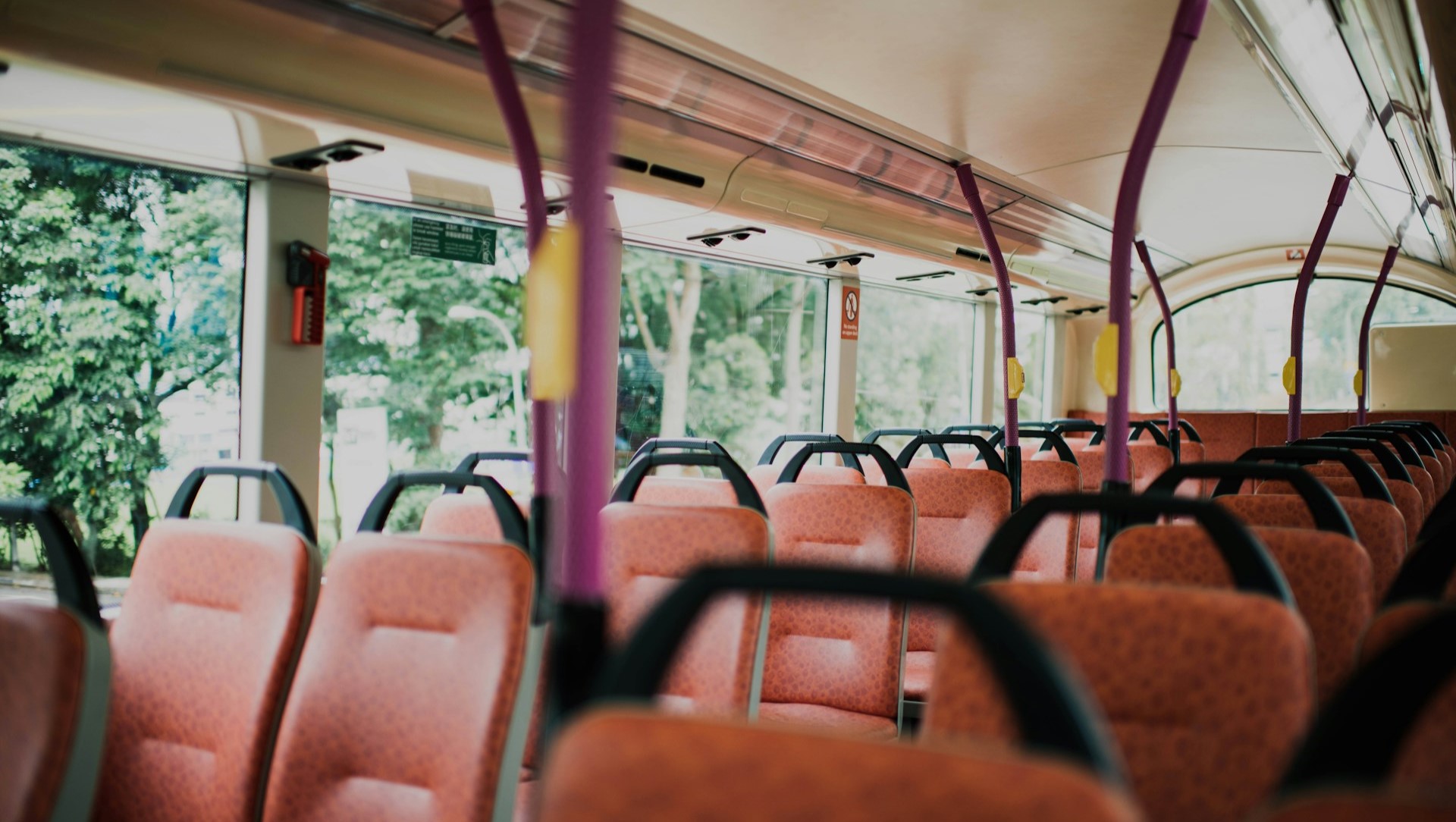 Image of the inside of an empty bus on a sunny day. 