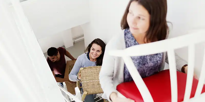 Three students moving furniture