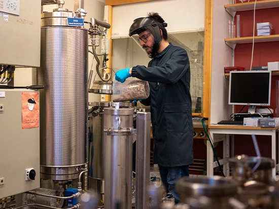 Student operating a laboratory scale circulation digester for producing wood pulp.