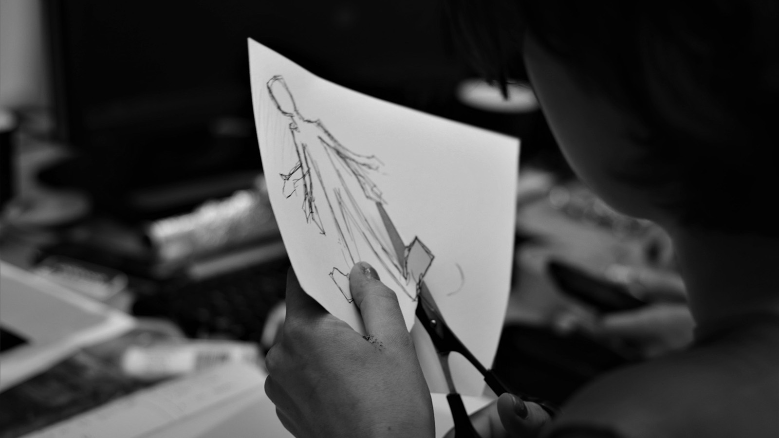 person cutting a sheet of paper