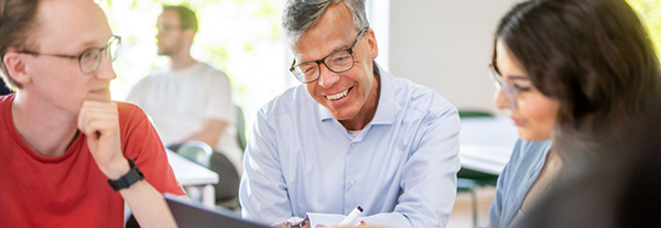 Två studenter får instruktioner av lärare