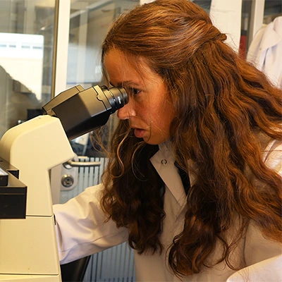 Woman looking into microscope