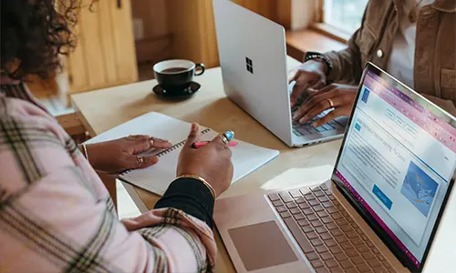 Två personer sitter med laptops och studerar ihop