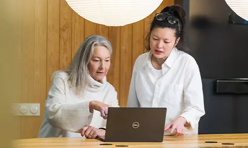 Två personer tittar på en laptop