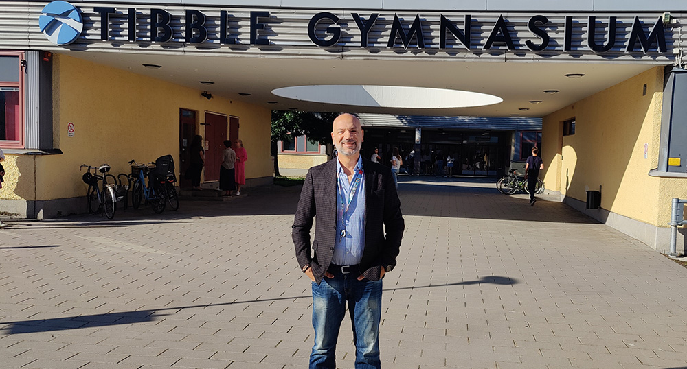 Teacher in front of Tibble gymnasium.