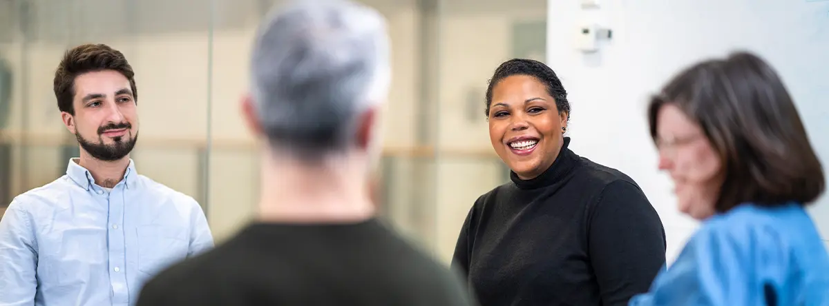 Fyra personer sitter i ett möte