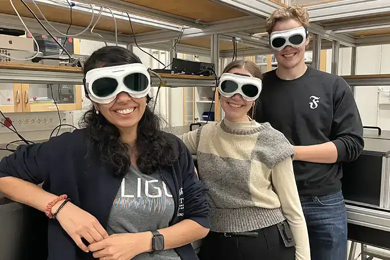 Three people wearing sunglasses in a lab.