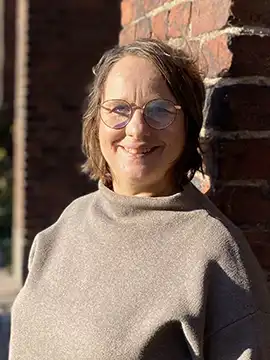 Woman in brown sweater.