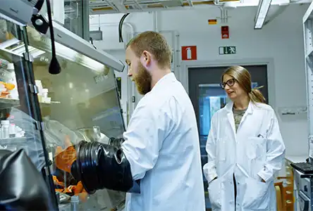 One man and a woman in a research environment.