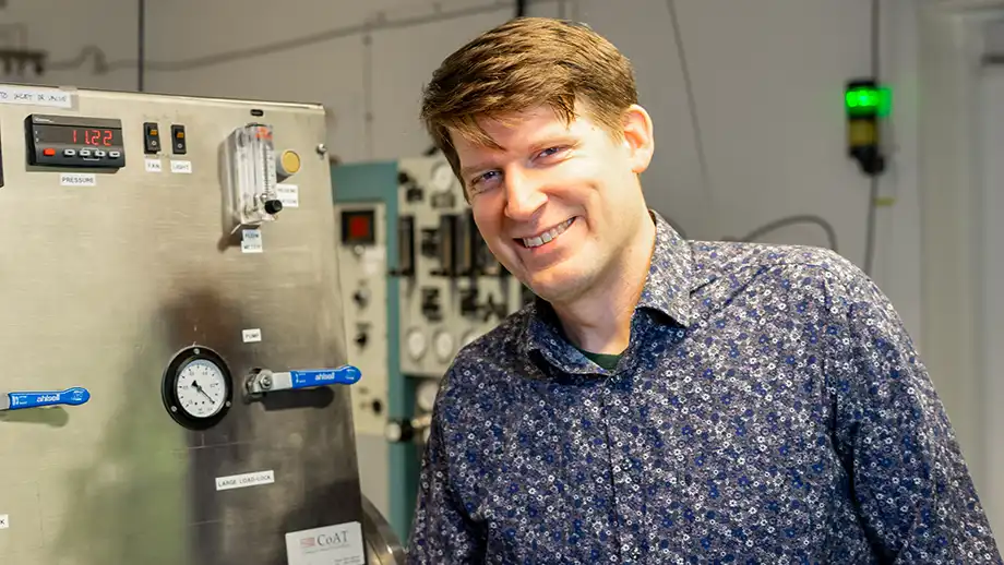 Man stående framför labbmaskin.