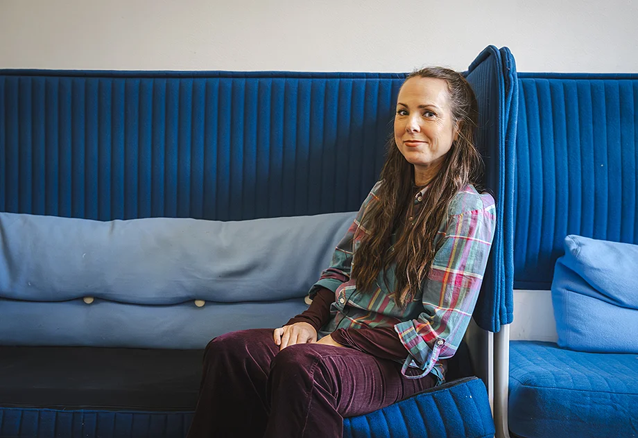 Woman sitting in a blue sofa chair.