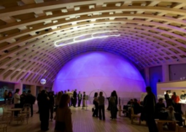 Crowd in front of a pink lit dome