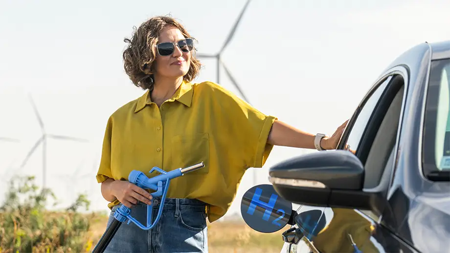 Woman fueling her car with a hydrogen fuel pump.