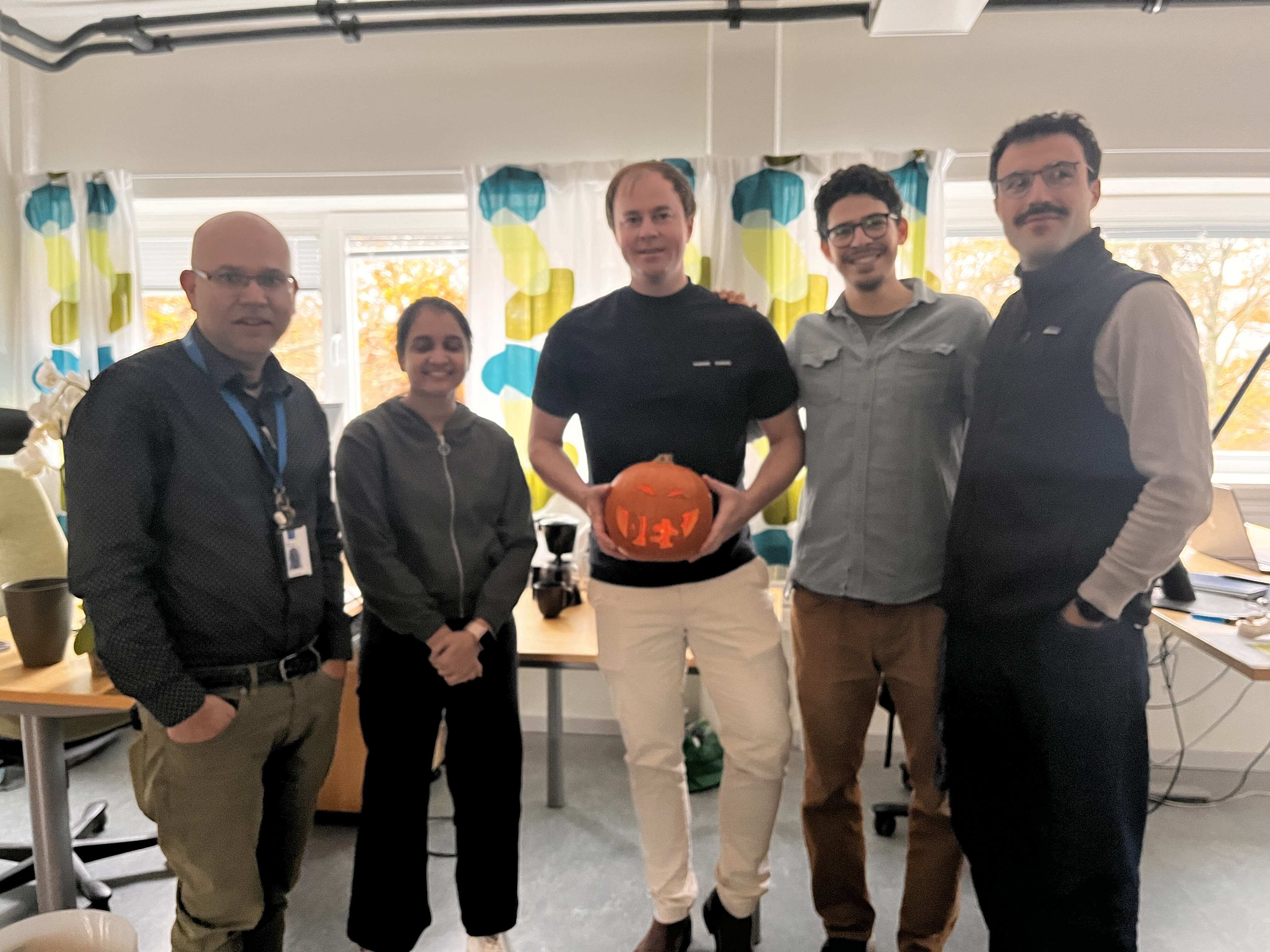 The picture shows Corrado and his colleagues in the office, and a carved Halloween pumpkin.