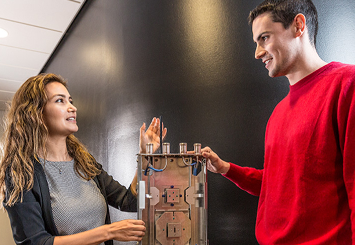 A female and a male discussing a technical device